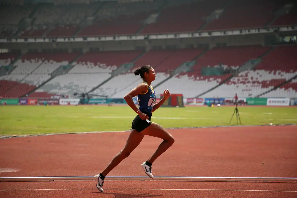 Alergătoare pe pista unui stadion, într-un sprint cu efort cardio intens